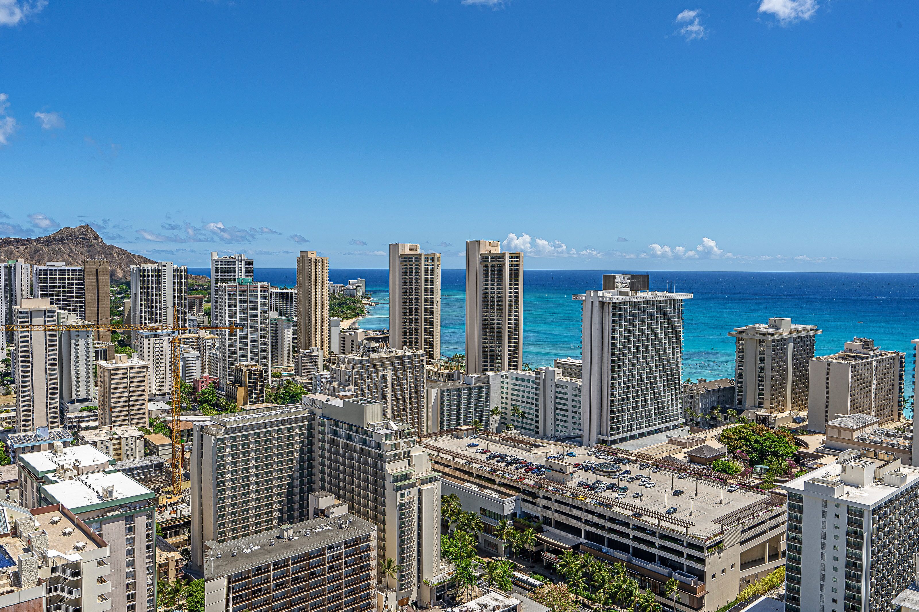 A high-rise hotel with multiple floors, a parking garage, and a view of the ocean.