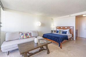 Ein Schlafzimmer mit einem Bett, einem Schlafsofa, einem Couchtisch und einem Nachttisch.