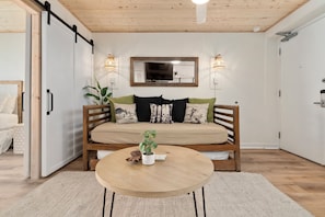 Ein gemütliches Zimmer mit einer Polksitzbank, einem runden Holztisch und einem Blumentopf.