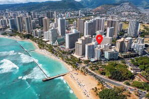 Un paisaje urbano costero con edificios altos, una playa y un muelle.