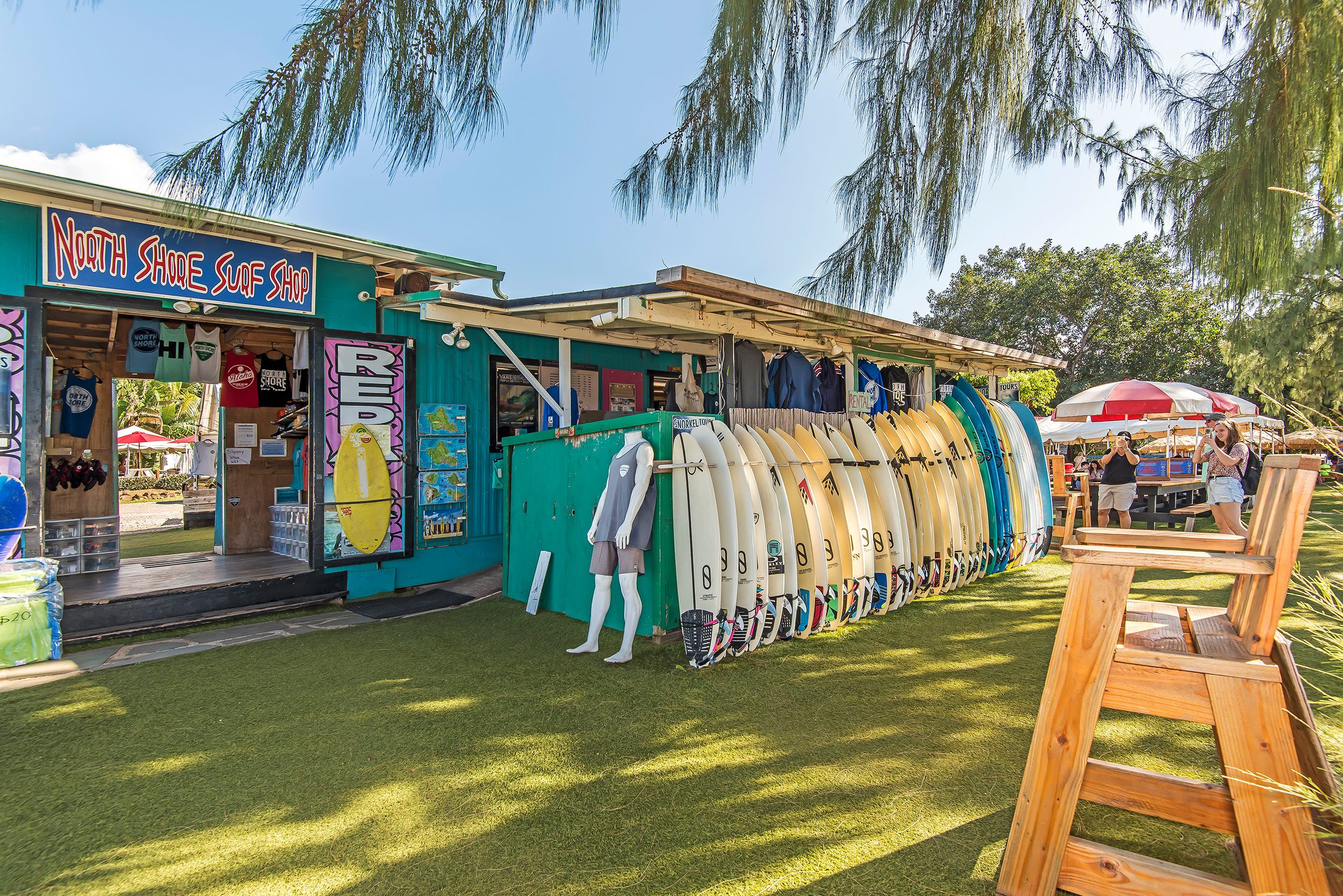 A surf shop with a variety of surfboards displayed outside.