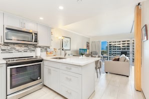 A modern kitchen with a built-in oven, microwave, and a large island with a sink. - Ocean-sunset Views at Ilikai Hotel Couples Getaway W/fabulous Amenities (Honolulu)