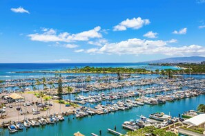 A marina with numerous boats docked, a clear blue sky, and a distant view of a coastline. - Ocean-sunset Views at Ilikai Hotel Couples Getaway W/fabulous Amenities (Honolulu)