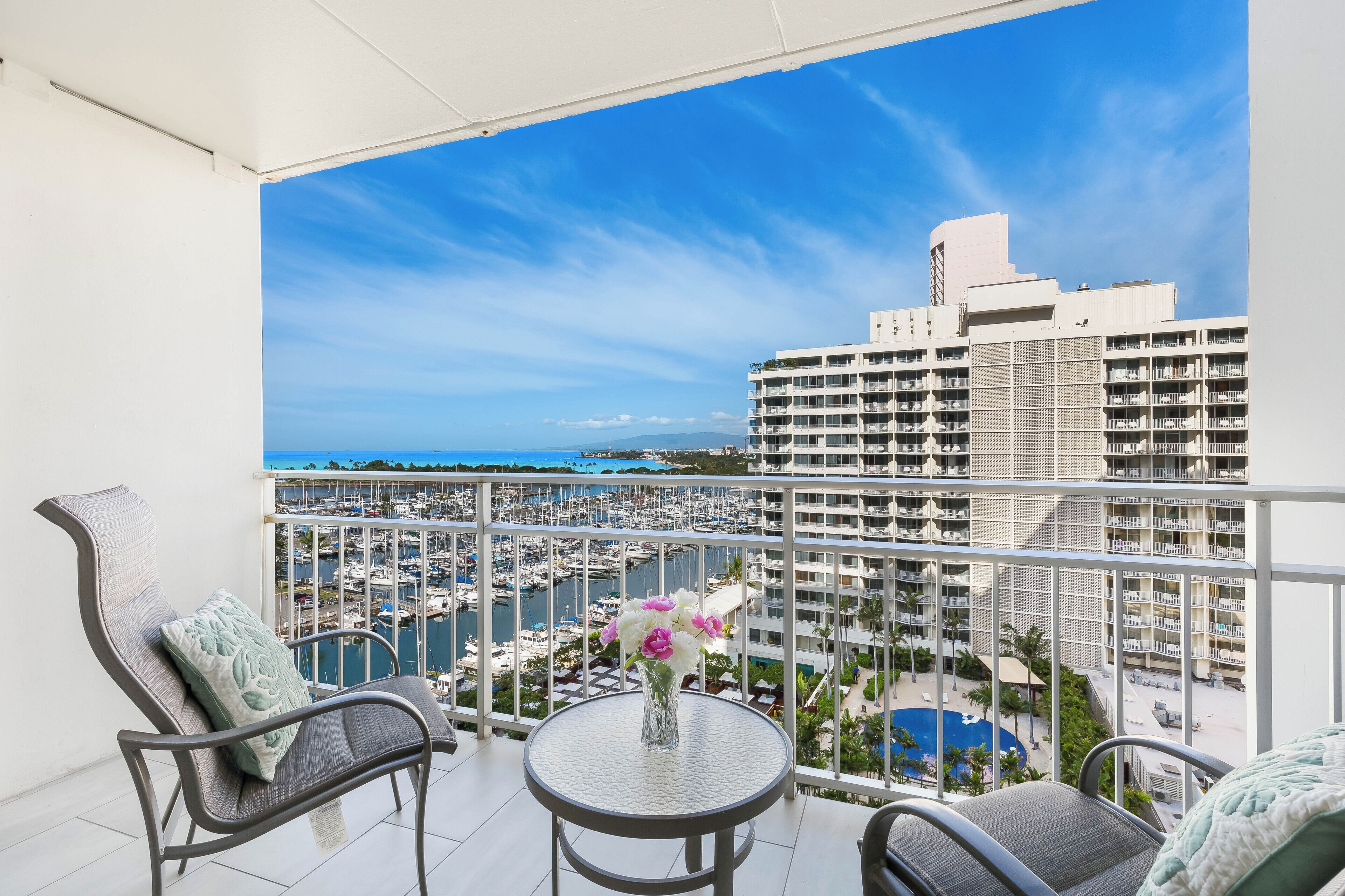 A balcony with a view of a marina and a hotel building.