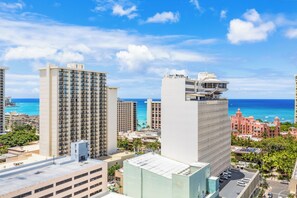 A high-rise hotel with multiple floors, a rooftop pool, and a view of the ocean. - Ocean-mt Renovated Marine Surf Condo by the Beach W/parking and Kitchenette (Honolulu)
