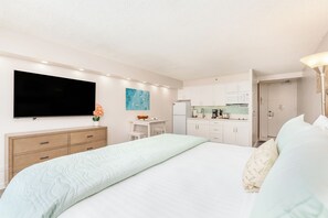 A hotel room with a bed, a TV, a kitchenette, and a bathroom. - Ocean-mt Renovated Marine Surf Condo by the Beach W/parking and Kitchenette (Honolulu)