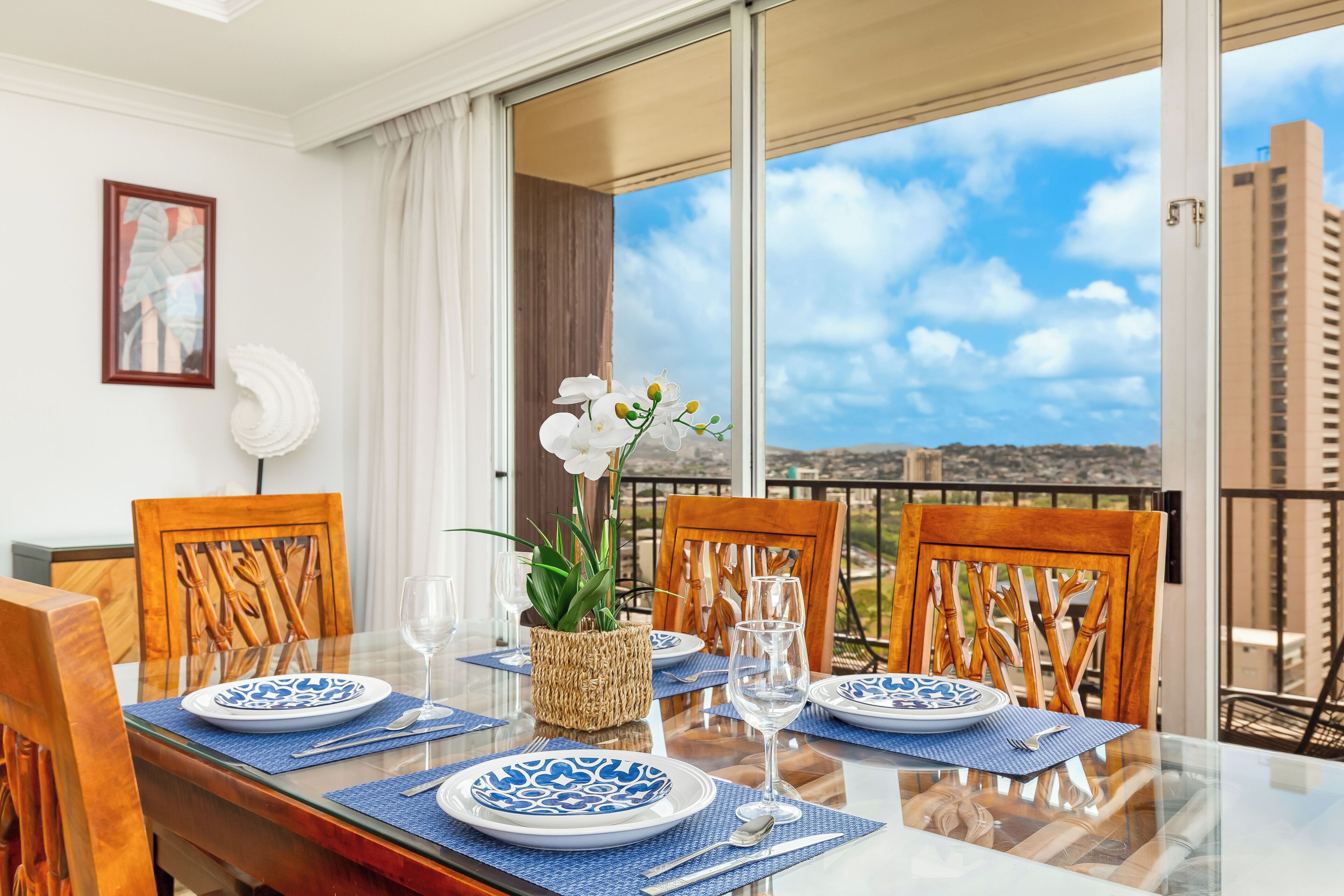 A dining table set with blue and white plates, a glass of water, and a vase with white flowers.