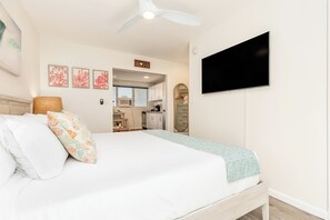 A hotel room with a bed, a television, and a kitchenette. - Remodeled Condo by the Beach at the Cabana Waikiki W/full Kitchen & Free Wifi (Honolulu)