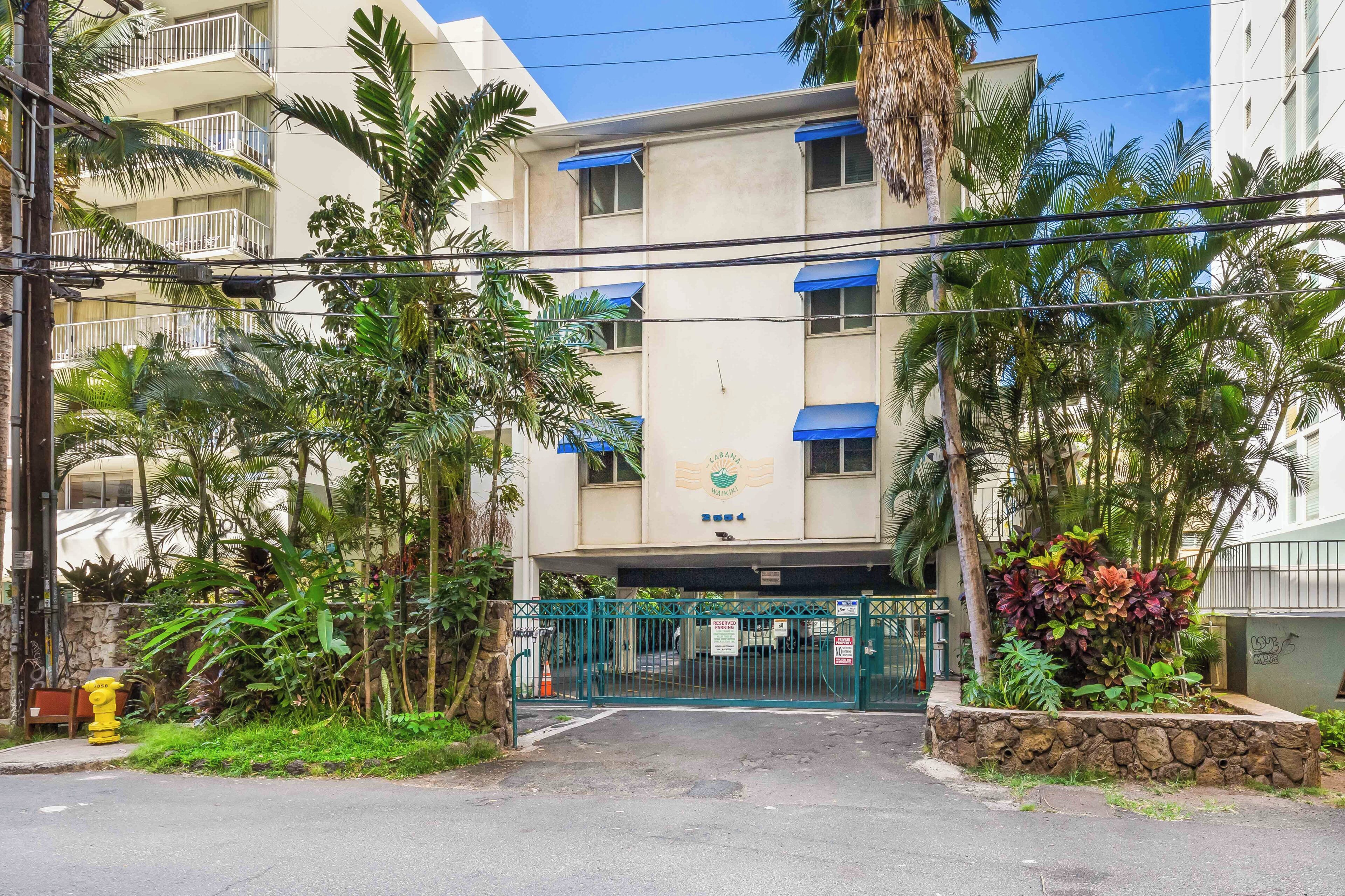 Un edificio con un letrero que indica 'CABANA WAIKI' y una entrada con un portón.
