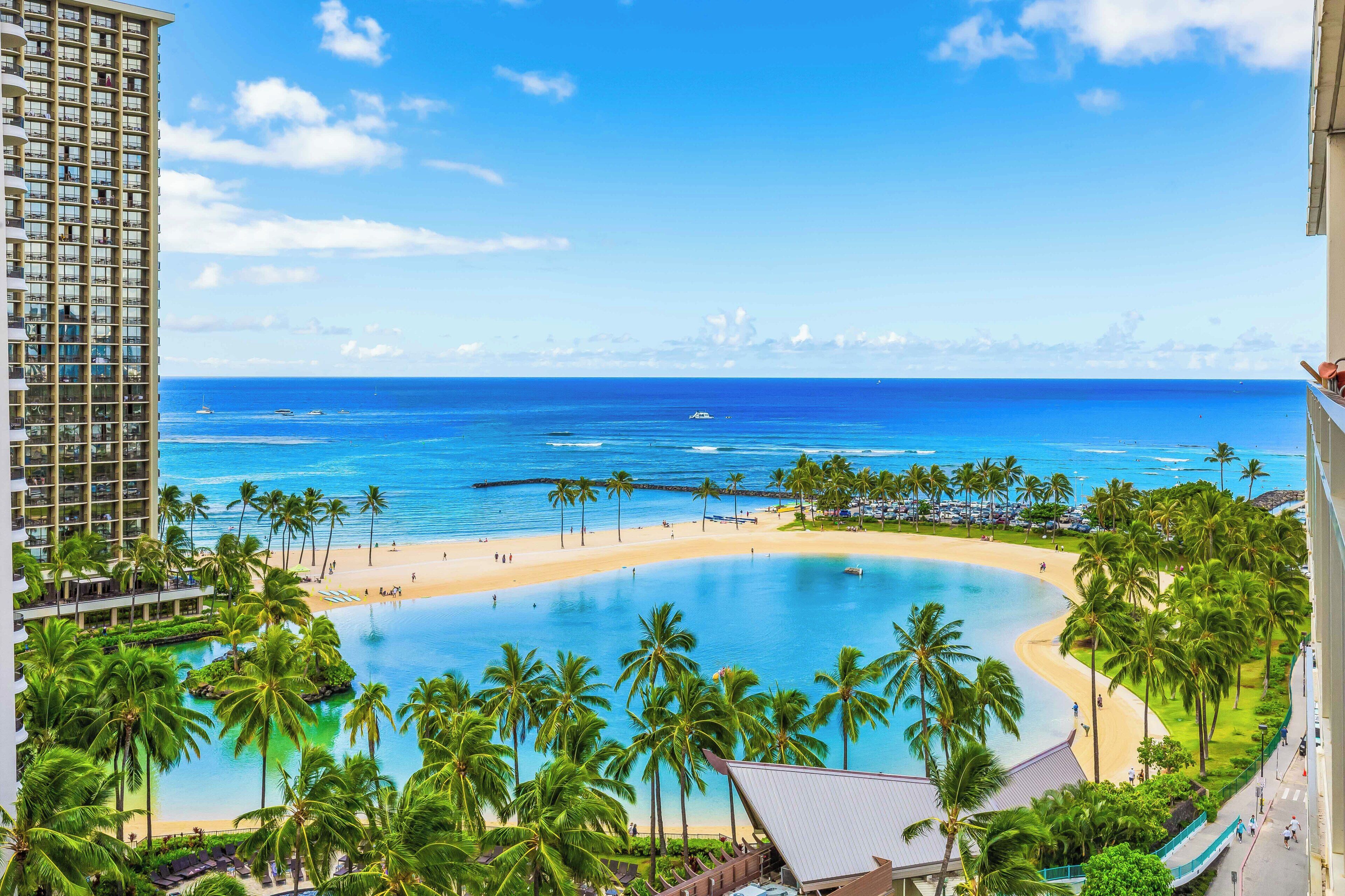 A resort with a large pool, beach, and ocean view.