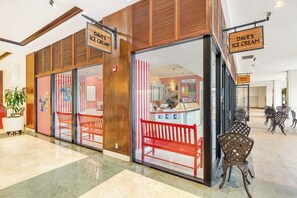 A restaurant with a red bench outside, a sign for Dave's Ice Cream, and a sign for Aroma Cafe. - Ocean & City Views Family-friends Paradise Retreat at Ilikai Hotel W/kitchen (Honolulu)