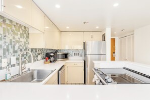 A modern kitchen with a stainless steel sink, a microwave, a refrigerator, and a dishwasher. - Ocean & City Views Family-friends Paradise Retreat at Ilikai Hotel W/kitchen (Honolulu)