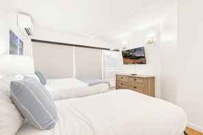 A bedroom with two beds, a TV mounted on the wall, and a wooden dresser. - Ocean & City Views Family-friends Paradise Retreat at Ilikai Hotel W/kitchen (Honolulu)