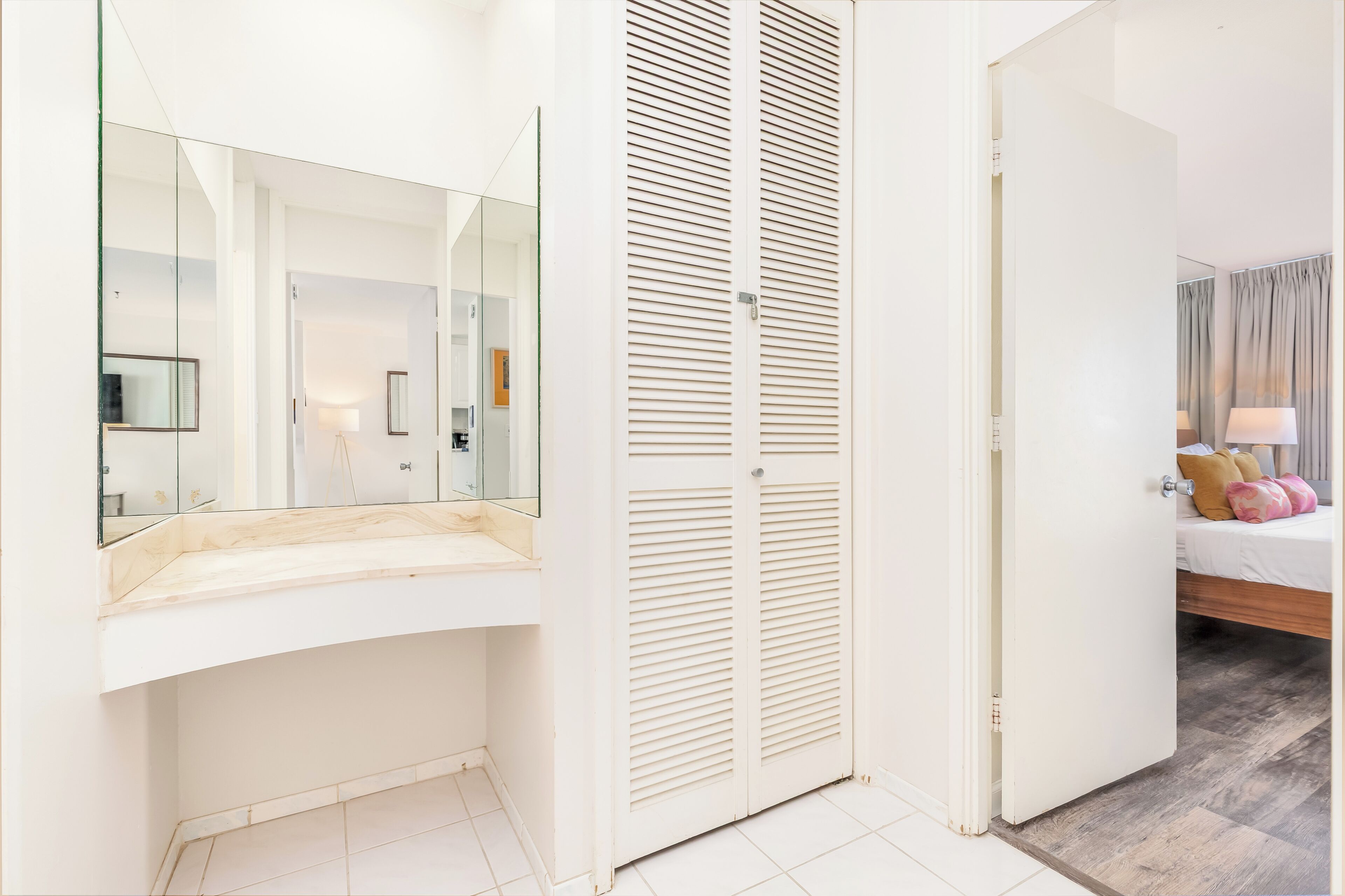Une salle de bain moderne avec une douche à parois de verre, un meuble-lavabo blanc et un grand miroir.