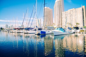 A marina with multiple boats docked, surrounded by tall buildings. - Marine Surf Waikiki Condo Short Walk to the Beach W/full Kitchen & Parking (Honolulu)