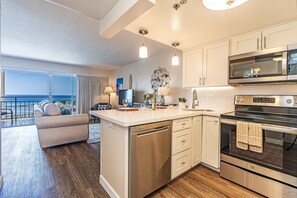 A modern kitchen with a central island, stainless steel appliances, and a view to the outside. - Ocean-marina Views Dream Vacation at Ilikai Hotel W/spectacular Amenities (Honolulu)