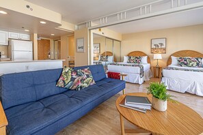 A hotel room with a sofa, two beds, a small table with a plant, and a bookshelf. - City & MT Views From the Ilikai Condo by the Beach W/full Kitchen & Free Wifi (Honolulu)