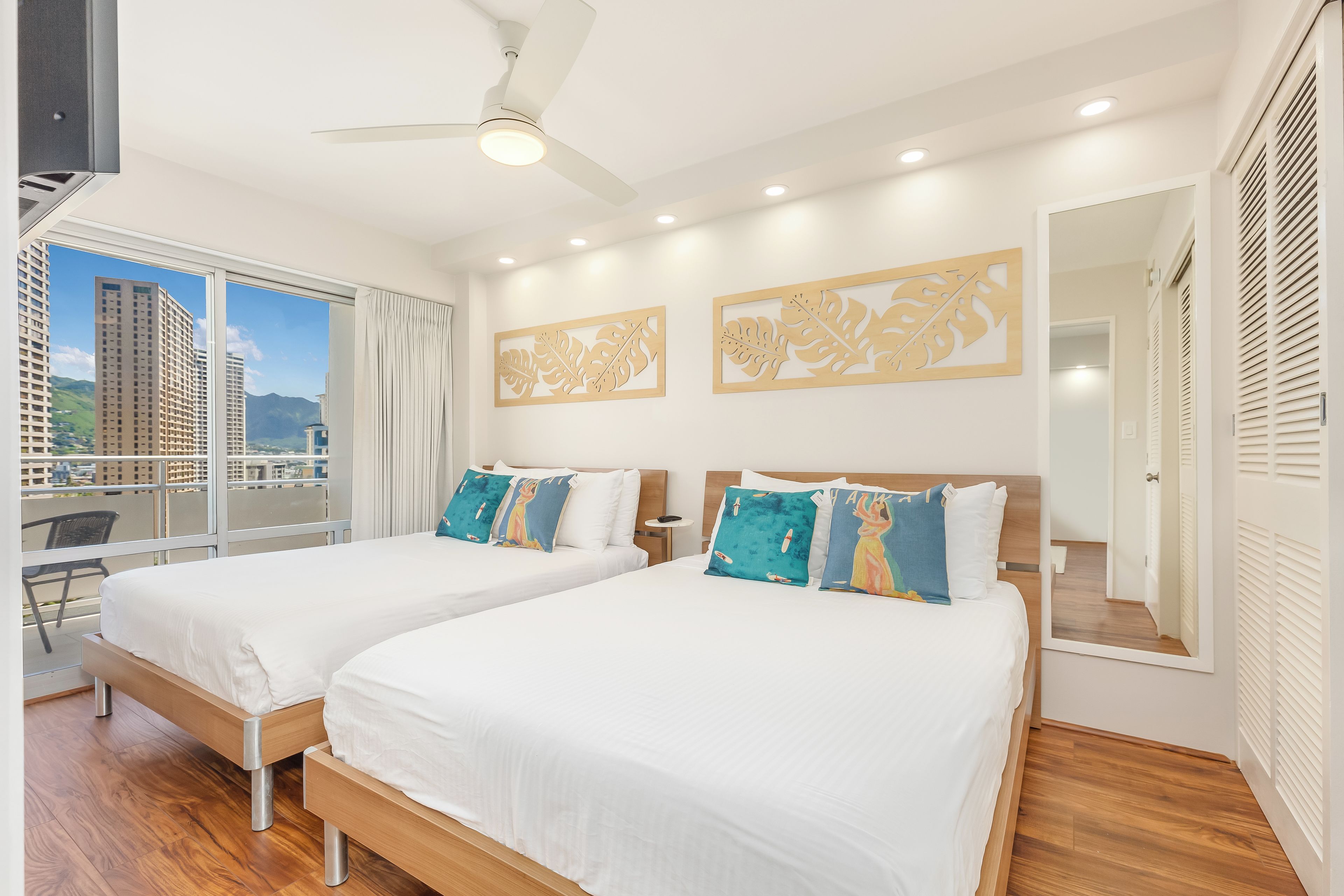 Habitación de hotel con dos camas, un balcón y vistas a la ciudad.