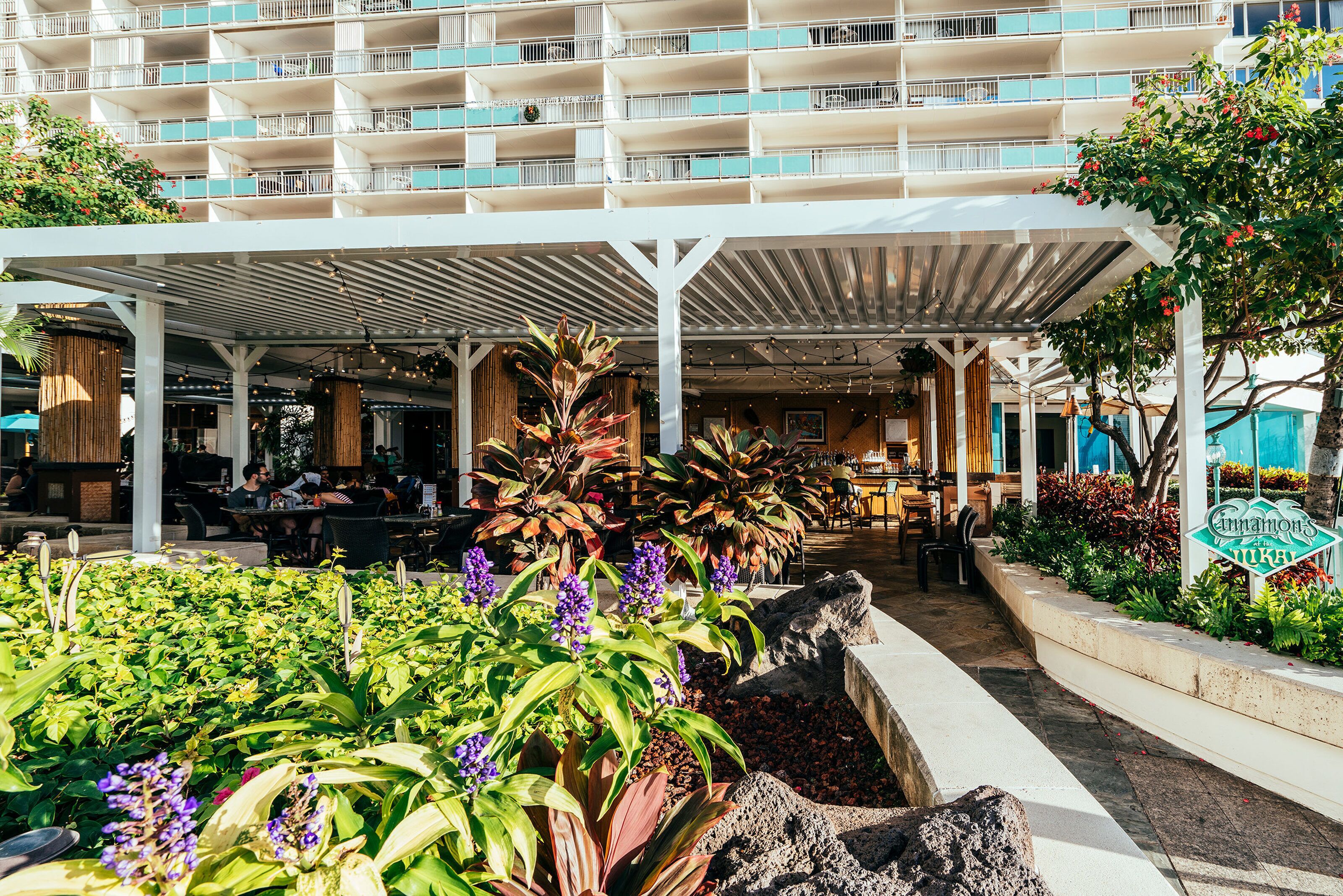 Un hôtel doté de nombreux balcons, d’un espace extérieur aménagé et d’une grande variété de plantes.