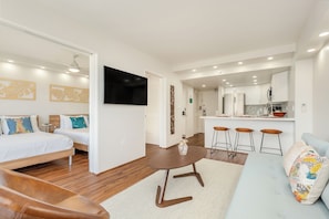 A modern hotel room with a bed, sofa, and a small dining area with stools. - Tropical City Escape at Ilikai Hotel by the Beach W/great Building Amenities (Honolulu)