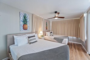 A hotel room with two beds, a ceiling fan, and artwork on the walls. - Diamond Head View Rare Condo at the Waikiki Banyan by the Beach With Parking (Honolulu)