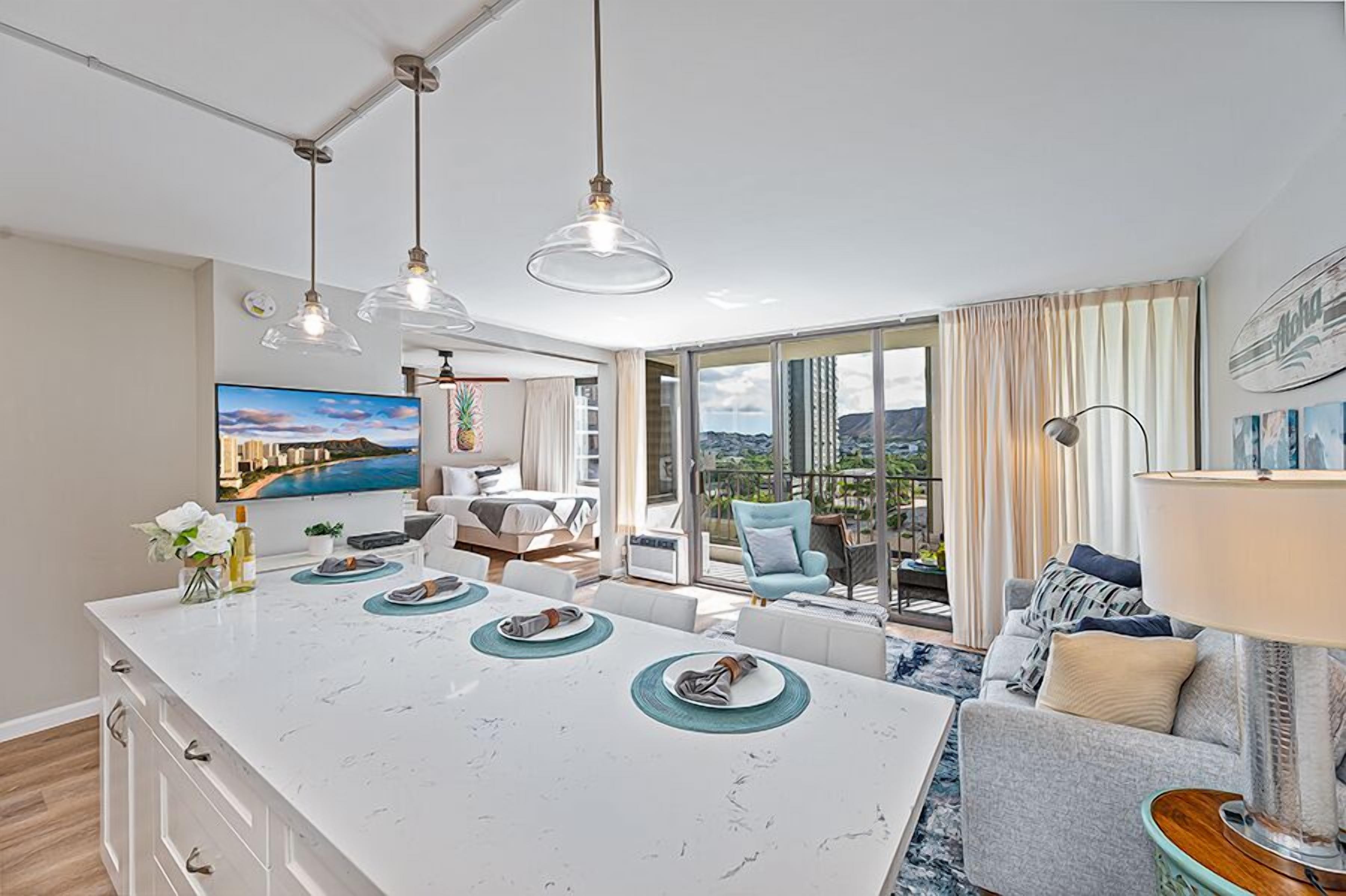 A modern kitchen with a large island, dining area, and a view of the outdoors.