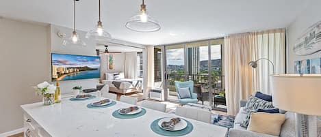 Una cocina moderna con una isla grande, comedor y vistas al exterior.