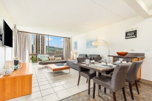 Un salon moderne avec un coin repas, de grandes fenêtres et une vue sur la ville.