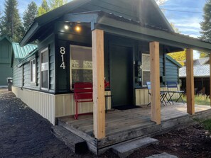 A small house with a porch, a number 814 sign, and a red chair outside. - Warm and Cozy 2-bedroom house in fabulous McCall with AC (McCall)