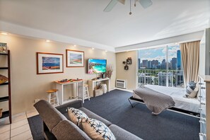 Uma sala de estar moderna com sofá, televisão e obras de arte nas paredes.