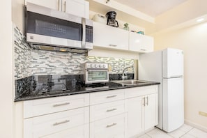 Eine moderne Küche mit Mikrowelle, Backofen und Kühlschrank.