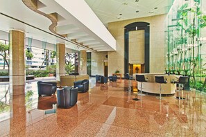 A spacious lobby with a marble floor, seating areas, and a reception desk. - Panoramic Cityscape Condo at the Waikiki Landmark W/great Building Amenities (Honolulu)