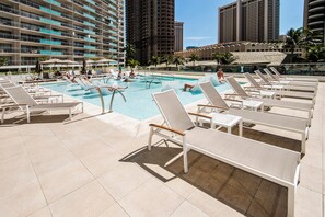 A rooftop pool area with multiple lounge chairs and a swimming pool. - Ocean & City Views Family-friend Vacation Getaway at Ilikai Hotel by Beach (Honolulu)
