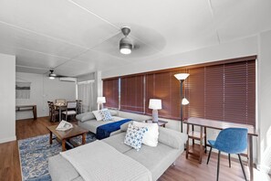 A modern living room with a sofa, a dining table, and a ceiling fan. - Ocean & City Views Family-friend Vacation Getaway at Ilikai Hotel by Beach (Honolulu)