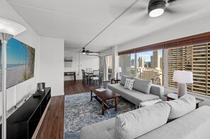 Uma sala de estar moderna com sofá, mesa de centro e um espaço de jantar com cadeiras e mesa.