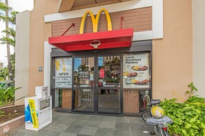 A McDonald's restaurant with a red awning, glass doors, and a bicycle parked outside. - Ocean-marina Yacht Views Condo Steps to the Beach W/full Kitchen & Free Wifi (Honolulu)
