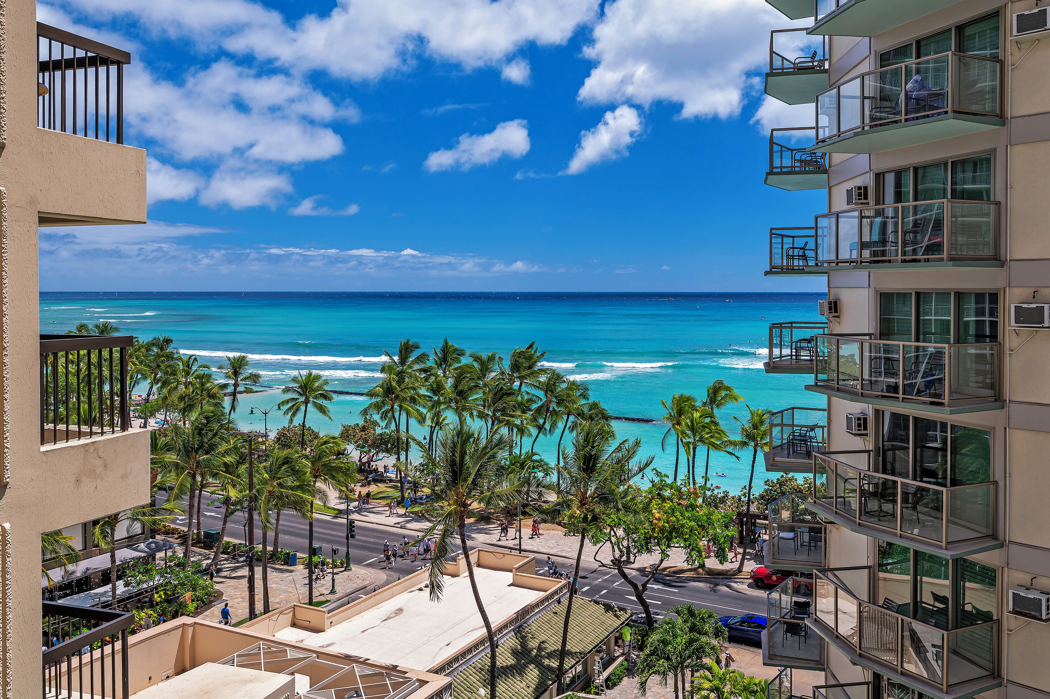 A high-rise hotel with balconies overlooking a beach and ocean.