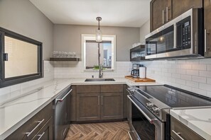 A modern kitchen with a built-in oven, microwave, and stainless steel appliances. - Ocean-beach Vacation Condo at Waikiki Beach Tower W/amazing Hotel Amenities (Honolulu)