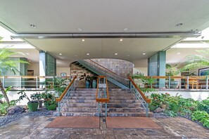 A staircase with a handrail, surrounded by potted plants and a stone wall. - Ocean-marina Views at Ilikai Marina W/full Kitchen Short Walk to the Beach (Honolulu)