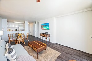A modern living room with a dining area, a kitchen in the background, and a large window with a view. - Ocean-marina Views at Ilikai Marina W/full Kitchen Short Walk to the Beach (Honolulu)