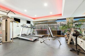 Ein Fitnessstudio mit Laufbändern, Kraftgeräten und einem Rudergerät.