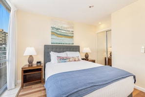 A hotel room with a large bed, two bedside tables with lamps, a large window with curtains, a painting on the wall, and a wardrobe. - Ocean-marina Views PH at Ilikai Hotel by the Beach W/full Kitchen & Free Wifi (Honolulu)