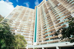 A high-rise hotel with multiple balconies, a central vertical structure, and surrounding greenery. - Ocean-marina Views PH at Ilikai Hotel by the Beach W/full Kitchen & Free Wifi (Honolulu)