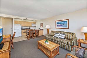 A compact living space with a kitchenette, a dining area, a sofa, and a television. - MT & Golf Course Views Waikiki Sunset by the Beach W/full Kitchen & Wifi (Honolulu)