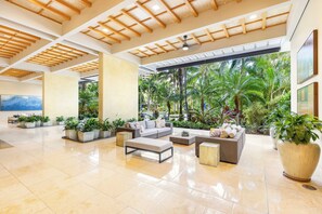 A spacious lobby with a high ceiling, large windows, and a view of tropical greenery. - Ocean-city Views Glamorous Condo at The Watermark W/parking & Full Kitchen (Honolulu)