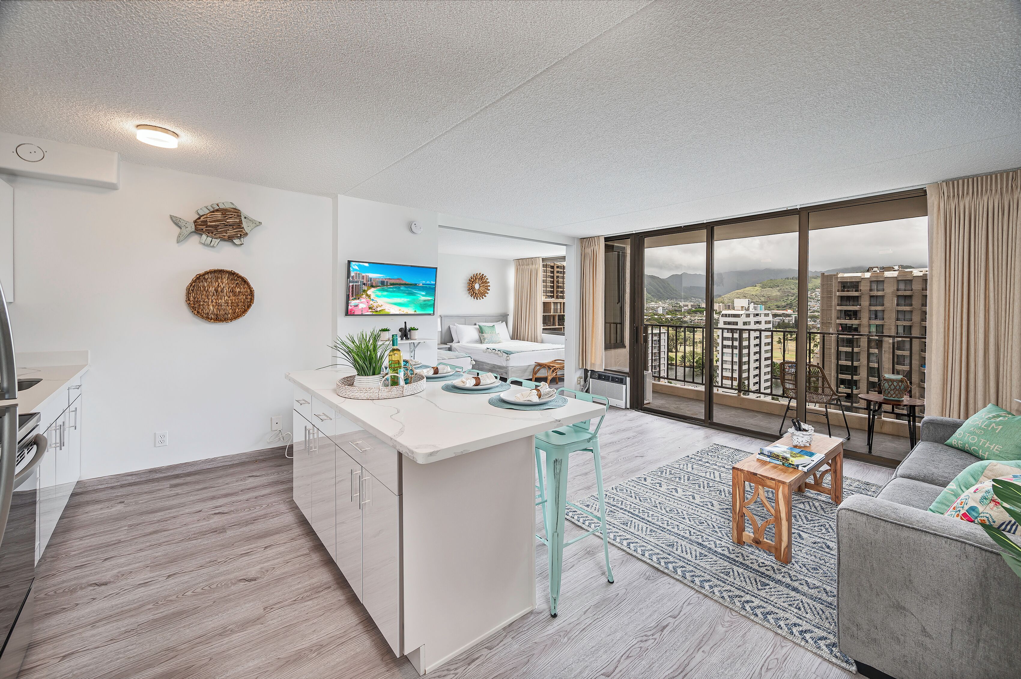 Een modern appartement met een keukenbar, een eethoek en een woonkamer met een groot raam met uitzicht op de stad.