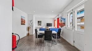 A dining area with a table and chairs, a fire extinguisher, and artwork on the walls. - Cosy 1Bdr Flat in Faro Downtown by LovelyStay (Faro)