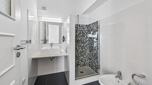 A modern bathroom with a shower, sink, and mirror. - Cosy 1Bdr Flat in Faro Downtown by LovelyStay (Faro)