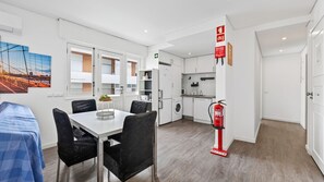 A modern kitchen with white cabinets, a washing machine, and a fire extinguisher. - Cosy 1Bdr Flat in Faro Downtown by LovelyStay (Faro)