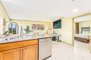 A modern kitchen with a dishwasher, wooden cabinets, and a granite countertop. - Luana at Waikiki 1-bed Ocean View Getaway in the Heart of Waikiki (Honolulu)